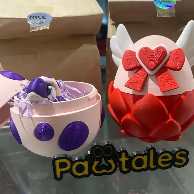 Huevo de Rexy morado dentro con Rexy dentro, junto al huevo de Cora con corazón rojo